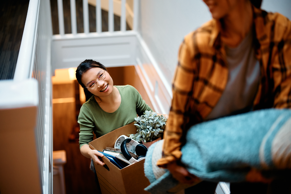 Woman walking up the stairs carrying a box