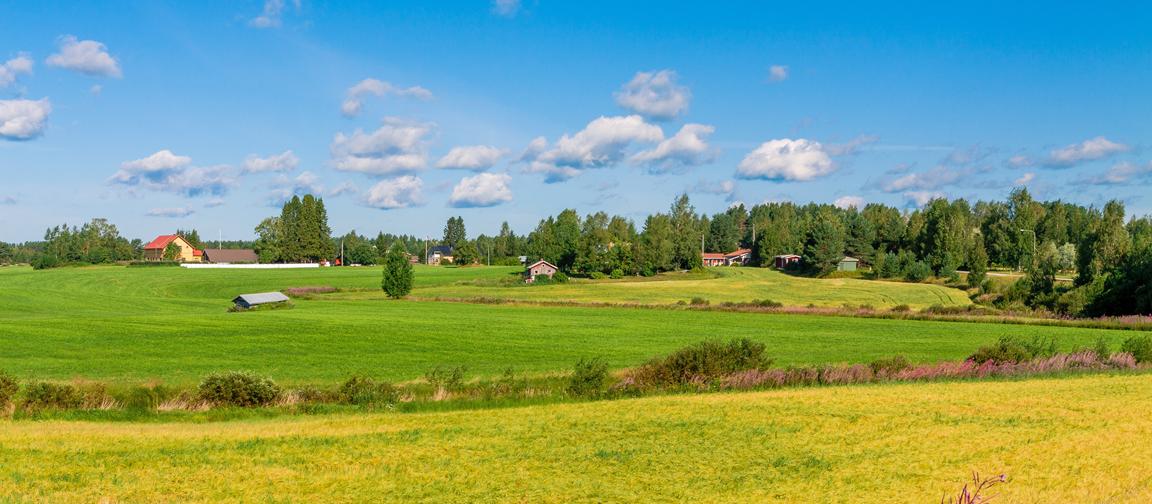 View of hilly Iowa fields with houses in the distance