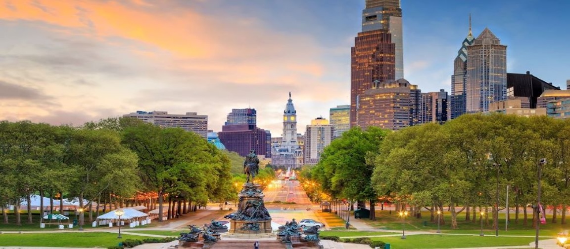 View looking down street towards the city with statue in the foreground